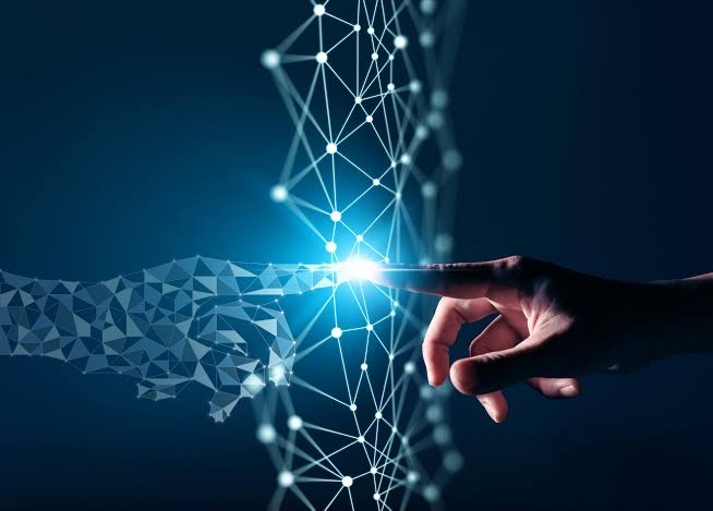 A human hand and a digital hand touch each other in front of a glowing network of nodes